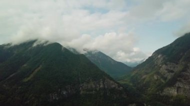 Havadan görünüm. Güzel bulutların içinde yüksek dağlar üzerinde uçan. Havadan kamera çekimi.