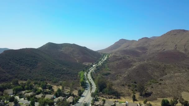 Drone aéreo sobre campo e longa estrada sinuosa, Califórnia, EUA — Vídeo de Stock