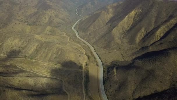 Luchtfoto drone over landschap en lange kronkelende weg, Californië, Usa. Langzaam vliegen — Stockvideo