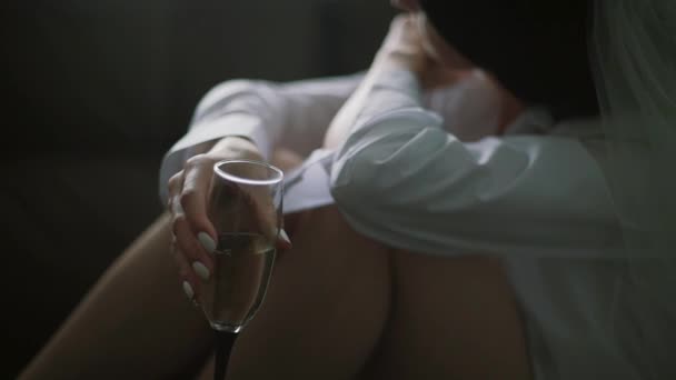 Молодая женщина или невеста в нижнем белье с бокалом шампанского, пьющие вид сверху — стоковое видео