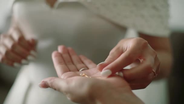 The bride takes the earrings from the hand of the girlfriend — Stock Video