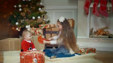 Şaşırtıcı baktı ona bir hediye vermek bir litle kız şirin küçük erkek ya da kız bu elleri bir şekilde dekore edilmiş Noel ağacı ve Hediyelik yakınındaki alkışlar heyecanlı. Orta vurdu