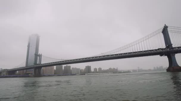 Небоскрёбы Манхэттена и Манхэттенского моста, Нью-Йорк. туман над небоскребами, облачная погода и движение на реке — стоковое видео