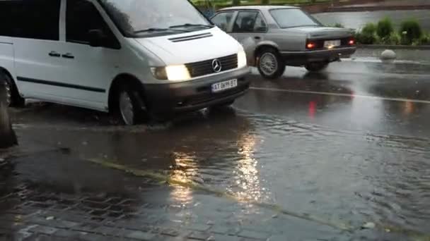 Après une pluie torrentielle, les gens conduisent leur voiture dans la rue inondable. Ferme là. 28 août 2018. Ivano-Frankivsk. Ukraine — Video