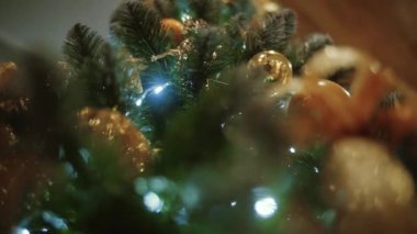 Bir Noel ağacı Noel ağacı oyuncaklar ve parlayan ışıklar, altın bokeh etkisi ile dekore edilmiştir. kamera yukarı taşıyın. Yakın çekim