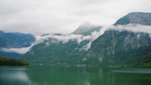 Vista panorámica desde el dron en el lago del Hallstatt rodeado de montañas en las nubes. Austria naturaleza. tiro medio — Vídeos de Stock