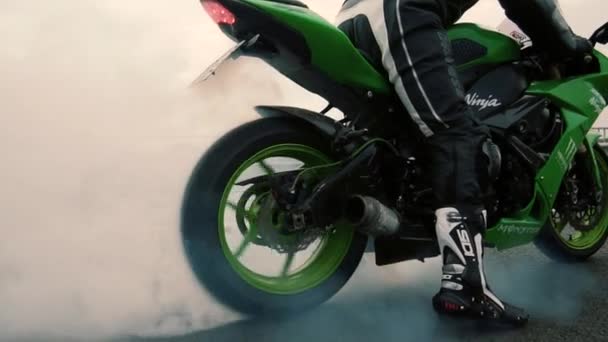 Ruota di moto sportiva che inizia a girare su asfalto e pneumatici burnout con un sacco di fumo. Al rallentatore da vicino. Ukraina Lviv 17 agosto 2018 — Video Stock