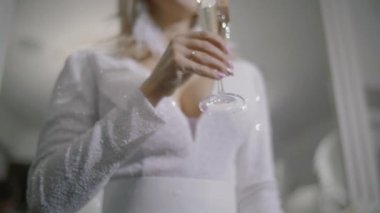 Seksi model kadın beyaz elbise giyiyordu, şampanya tatil parlak arka plan üzerinde içki şampanya ile. Noel ve yeni yıl kutlama, ağır çekim