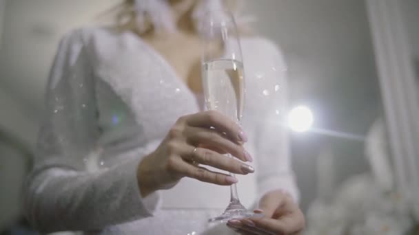 Sexy model woman with glass of champagne wearing white dress, take champagne over holiday glowing background. Christmas and New Year celebration, Slow motion — Stock Video