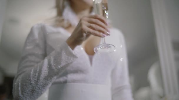 Sexy model vrouw met glas champagne dragen witte jurk, champagne drinken op vakantie gloeiende achtergrond. Kerstmis en Nieuwjaar viering, Slow motion — Stockvideo