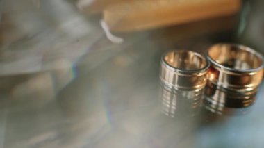 İki altın parlayan ışık ile bir tablo beyaz dekorasyon yatan alyans makroyu kapatın. Kan nakli ışık halkaları üzerinde... Yakın çekim