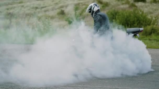 Спортивный мотоцикл начинает вращаться на асфальте и выгорание шин с большим количеством дыма. Медленное движение. Украина Львов 17 августа 2018 — стоковое видео