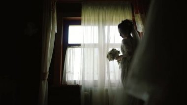Ahşap ev panoramik penceresinde boyunca bir beyaz ipek sabahlık konaklama içinde gelin