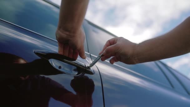 Masculino mecânico ou ladrão segurando Lockpicker para abrir a porta do carro. Fechar — Vídeo de Stock