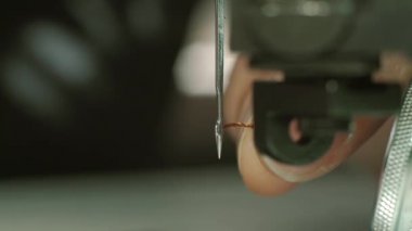 Bir iş parçacığı bir iğne göz boyunca yerleştirerek ve dikmek hazırlanıyor parmaklar. yakın çekim.