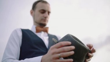 Doğa ile çevrili gülümseyen genç bir adam portresi. Bir şapka giyen adam. ağır çekim