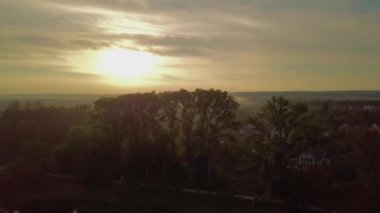Göl ve şehir güzel manzara havadan görünümü günbatımında ağaçların üzerinden uçmak