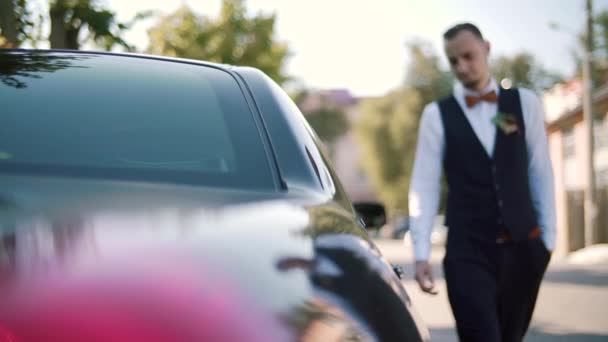 Empresario en un traje está caminando hacia un coche ejecutivo, cámara lenta — Vídeo de stock