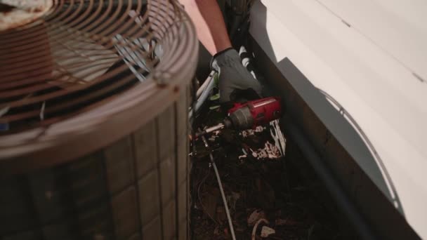 Man draait de schroef met een schroevendraaier op air conditioner. Close-up. Slow motion — Stockvideo