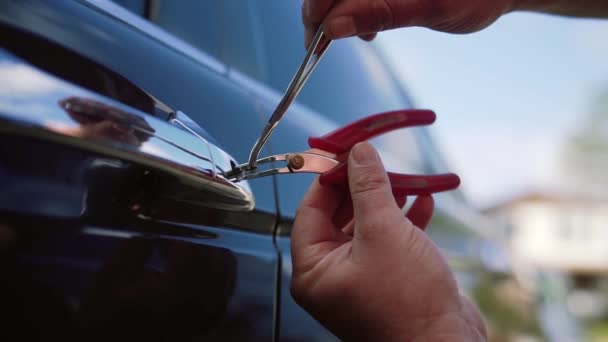 Mannelijke monteur of dief Holding Lockpicker aan Open auto deur. Close-up — Stockvideo