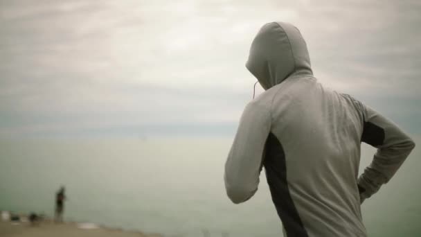 Молодой спортсмен бежит на фоне города и озера, камера сбоку вид, замедленное движение — стоковое видео