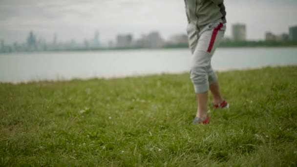 Un giovane atletico allenare esercizi di pugilato sullo sfondo della città e del lago, al rallentatore si muovono fotocamera — Video Stock