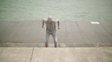 Genç atletik biri tren boks gerçekleştirir merdivenlerden şehir ve Gölü, ağır çekim arka planı egzersizleri stairson atlar gerçekleştirir. üstten görünüm