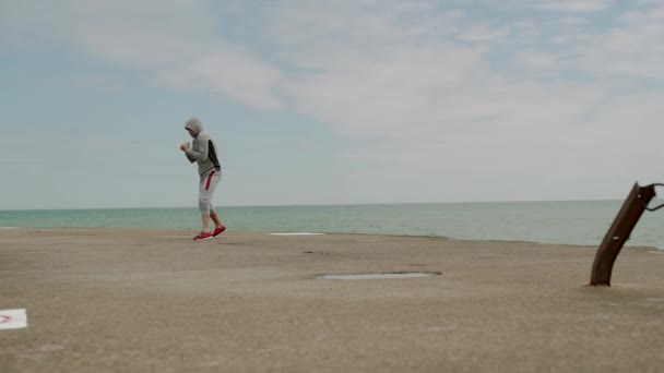 Jovem desportista, ativamente envolvido em esportes, crossfit, boxe, kickboxing na costa do lago, tiro largo, câmera lenta — Vídeo de Stock