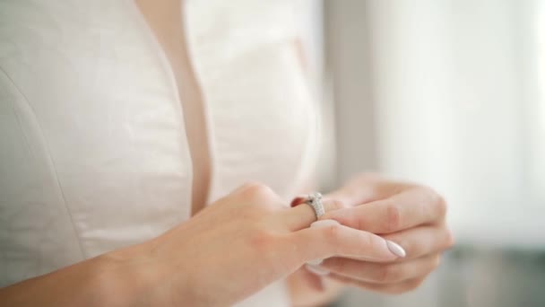 Vrouw dragen engagement trouwring op de vinger gepolijst nagels kant jurk zorgen te maken voor de ceremonie. Close-up — Stockvideo