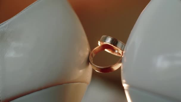 香水の婚約指輪のスプレーは、花嫁の結婚式の靴の間に配置されます。.閉じる。スローモーションマクロ — ストック動画