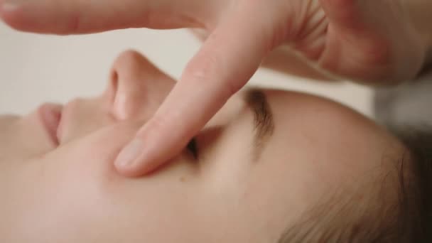 Spa masaje facial. masajear la cara y los ojosMasaje facial en salón de spa de belleza. De cerca. — Vídeos de Stock