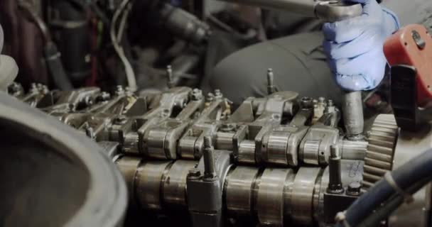 Réparation automobile. Le mécanicien tord la pièce sur le fond du moteur de la voiture ou du camion. Gros plan — Video