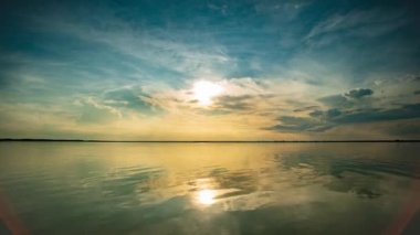 Zaman atlaması Işık akşam gökyüzü, göl günbatımı gökyüzü üzerinde bulutlar gerilmiş. Düz suda refleks