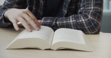 Üniversite kütüphanesinde eski ders kitabını okumak, kitap okumak