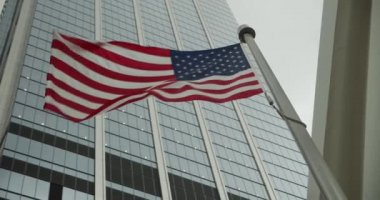 Amerikan Bayrağı gökdelenler Yavaş Waving arka plan karşı. Birleşik Devletler bayrağının yakın çekim. Abd