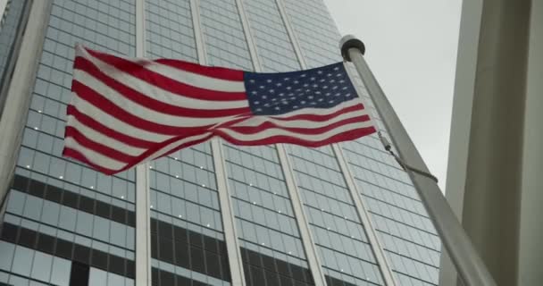 Bandera Americana contra el fondo de los rascacielos Slow Waving. Primer plano de la bandera de los Estados Unidos. Estados Unidos — Vídeos de Stock