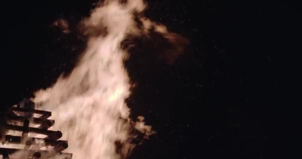 Eldflammor och gnistor i offer elden. Slow motion isolerad på svart, 4K närbild — Stockvideo