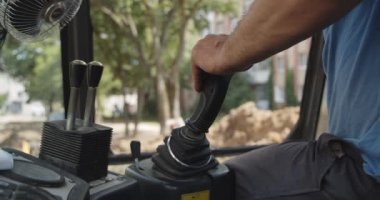 El kontrol joystick Ekskavatör adam Pov, Backhoe ev veya streer inşaat için çalışıyor. Sokak işi. Ekskavatör toprağı kazıyor.