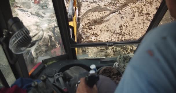 Vista da uomo escavatore POV, terne che lavorano per la costruzione di case o streer. Lavoro di strada. L'escavatore sta scavando il terreno — Video Stock