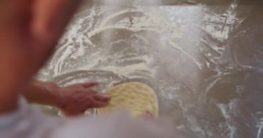 Fırıncının eli pizza hazırlamak için hamur yoğuruyor. Ağır çekim. Üst görünüm