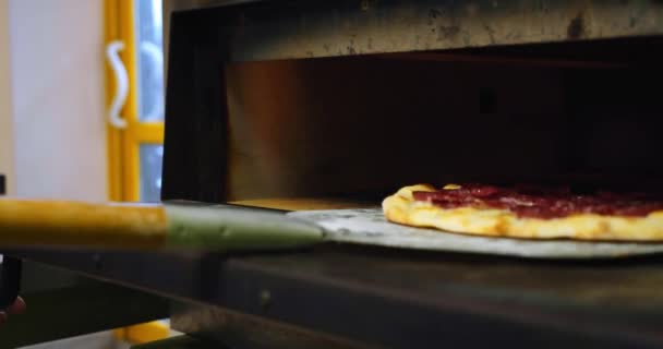 Szef kuchni trzyma drewnianą łopatę i wychodzi gotowa włoska pizza z piekarnika. Zamknij drzwi. Zwolnij trochę. Wartości 3 — Wideo stockowe