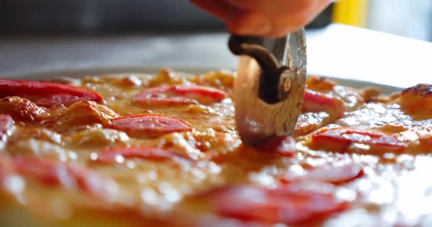 Chef cortando uma pizza de pepperoni em várias fatias com um cortador de pizza. Lento movimento close-up — Vídeo de Stock