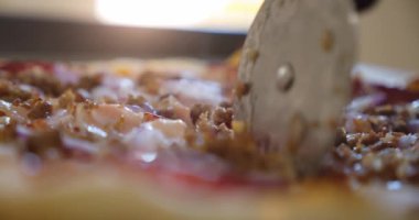Şef pizza kesicisiyle pepperonili pizzayı dilimliyor. Yavaş çekim yakın çekim. Ver 4
