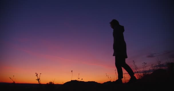 Kvinnan höjer händerna på den vackra bergstoppen ovanför den Gyllene solnedgången. Långsamma rörelser — Stockvideo