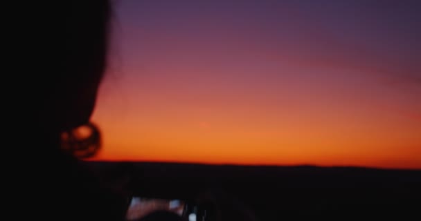 Silhueta mulher tirando fotos de belo pôr do sol com smartphone. Movimento lento — Vídeo de Stock