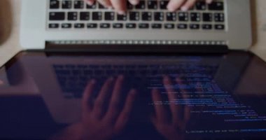 Anonim bir adam ekran dizüstü bilgisayarı, geliştirme ağı ve geliştirici üzerinde programlama yapıyor. Üst görünüm