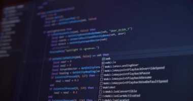 Kişisel Bilgisayar kullanarak yazılım uygulaması geliştiren bir mühendisin siyah bilgisayar ekranındaki programlayıcı kodlaması ve ekranda daktilo kodu. Yakın plan. Ver 5