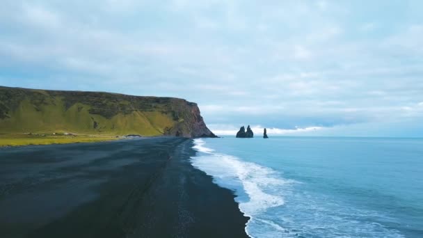 Hava aracı görüntüsü siyah kum kumsalı ve kaya oluşumlarını gösteriyor Reynisfjara, Vik İzlanda Reynisfjara Plajı Ver 6 — Stok video