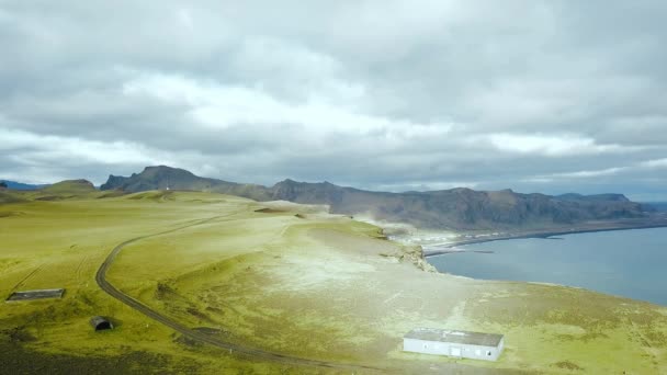 Luftaufnahmen von Drohnenflügen über den Berg in schwarzem Sand Strand und seine Felsformationen reynisfjara, vik iceland reynisfjara beach — Stockvideo