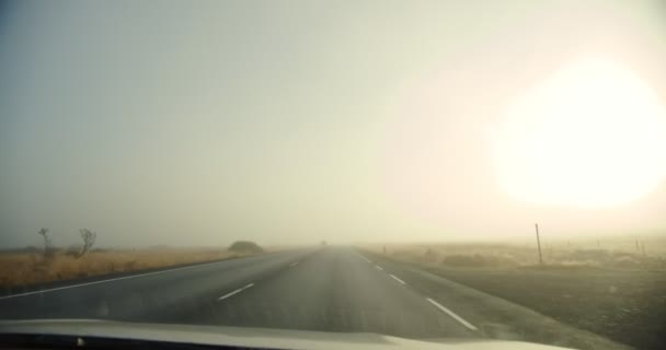 Punto de vista de los conductores perspectiva de la carretera en Islandia, vista desde la ventana del coche, el coche pasa a través de la niebla. Movimiento lento — Vídeos de Stock